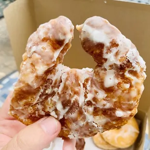 a hand holding a glazed donut