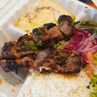 a chicken skewer and rice