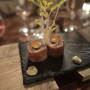 two sushi rolls on a slate plate