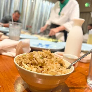 a bowl of rice with a chef in the background