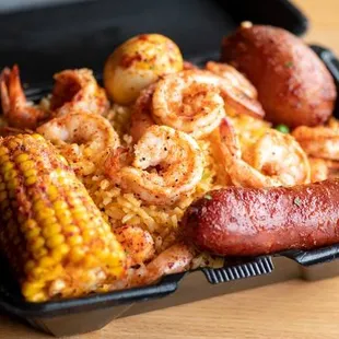 a tray of shrimp, corn, and sausage