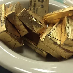 a bowl of gold wrapped chocolates