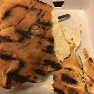 grilled flatbreads in a styrofoam container