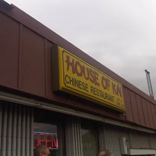 two people standing outside of a chinese restaurant