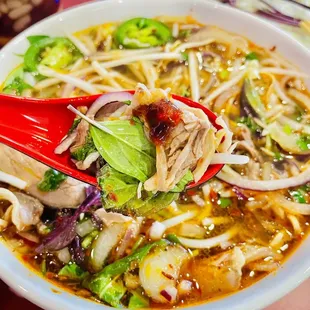 a bowl of soup with a red spoon