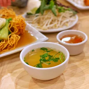 a bowl of soup and a plate of noodles