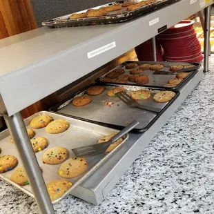 a counter with trays of cookies