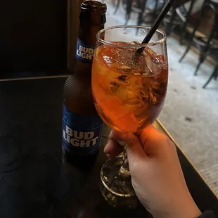 a person holding a glass of beverage