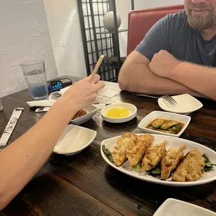 two men sitting at a table with plates of food