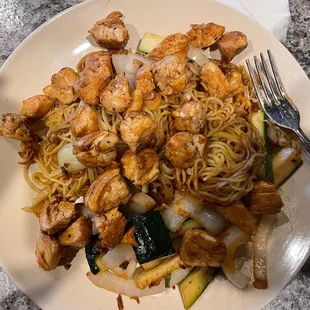 a plate of noodles and chicken