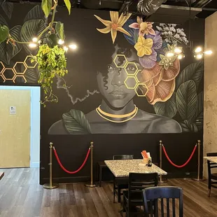 a mural of a woman with a beehive on her head