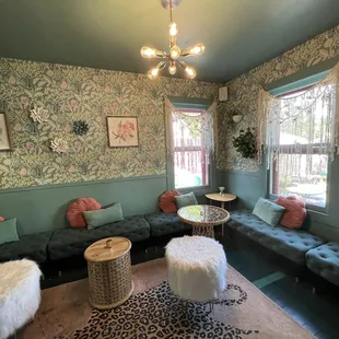 a living room with green walls and floral wallpaper