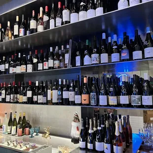 a wall of wine bottles and glasses