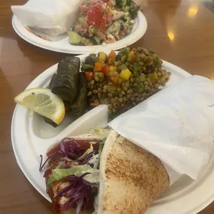 Falafel sandwiches with grape leaves, lentil salad, Greek salad, and tabouleh.