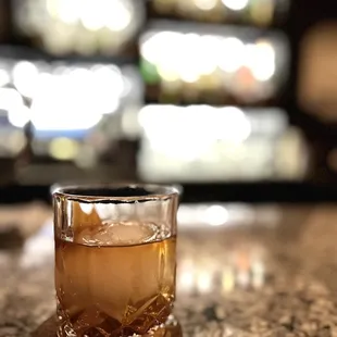 a glass of whiskey on a bar