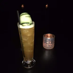 a cucumber cocktail with a cucumber garnish