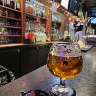 a glass of beer on a bar