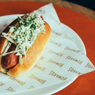 a hot dog on a paper plate