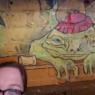 a woman in front of a painted wall