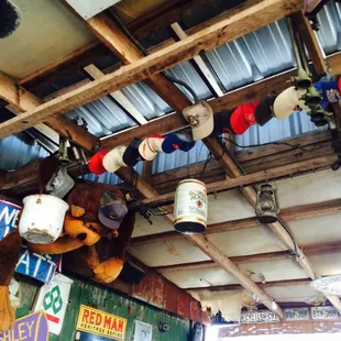 a variety of hats hanging from the ceiling