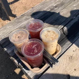 four different drinks on a picnic table