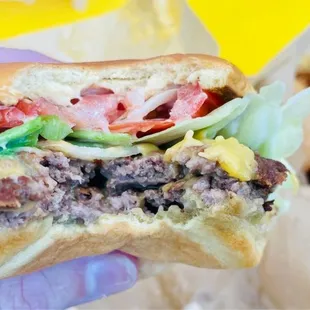 a hand holding a hamburger