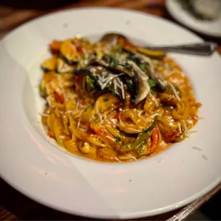 a plate of pasta with mushrooms and peppers