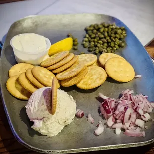 a tray of crackers, onions, and other ingredients