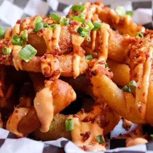 Onion Rings drizzled with our signature Dynamite sauce and topped with chopped applewood smoked bacon and green onion.