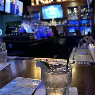 a glass of water with a lime garnish