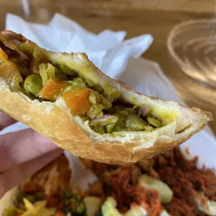 a hand holding a sandwich