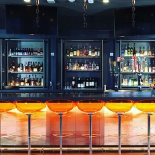a bar with orange stools