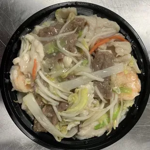 a bowl of noodles with meat and vegetables