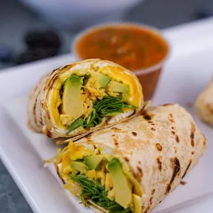 Breakfast wrap, avocado, fried egg, arugula &amp; cheddar on a flour tortilla.