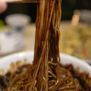 a bowl of noodles with chopsticks