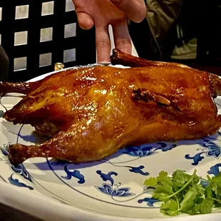 a roast chicken on a blue and white plate