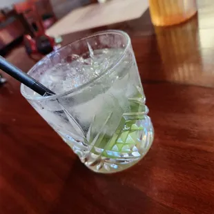 a glass of water with ice and a straw