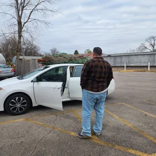 a man standing next to a white car