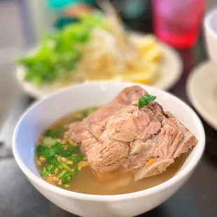 a bowl of soup with meat and vegetables