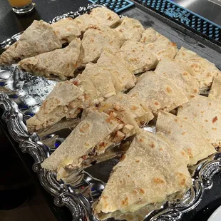 a tray of quesadillas and a glass of beer