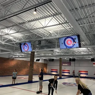 a group of people playing curling