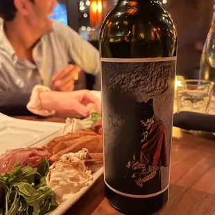 a bottle of wine and a plate of food