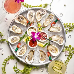 a platter of oysters with a cocktail