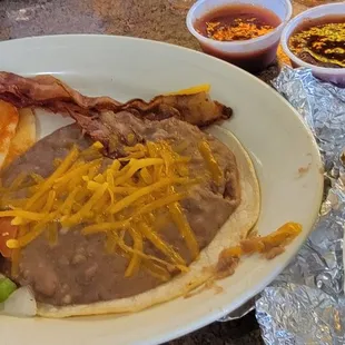 Huevos Rancheros w/ beans, bacon, tortillas