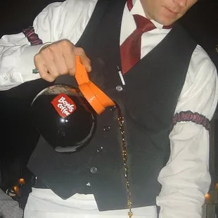 ...he pours the coffee into the glass as he lights the drink on fire...