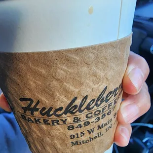 a hand holding a coffee cup