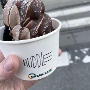 a hand holding a cup of ice cream