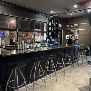 a bar with stools and tables