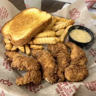 a basket of fried chicken, fries, and a sandwich