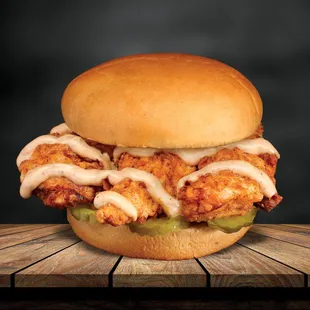 a fried chicken sandwich on a wooden table